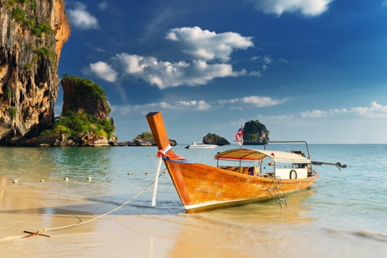 Thailand tropical beach with long-tail boats and clear blue water